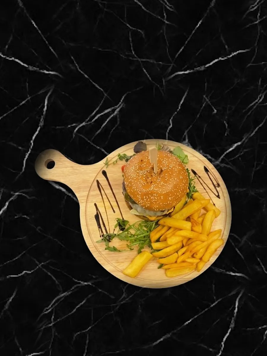 Burger sa pomfritom i rukolom na drvenoj dasci